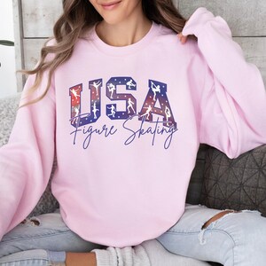 Pink USA Figure Skating sweatshirt with patriotic red white blue skater silhouettes, cozy crewneck skating mom shirt, winter competition fan apparel, ice skating gift for women.