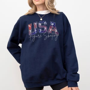Navy blue USA Figure Skating sweatshirt with red white blue skating silhouettes, patriotic winter sports crewneck, skating team supporter gift, ice skating competition apparel.
