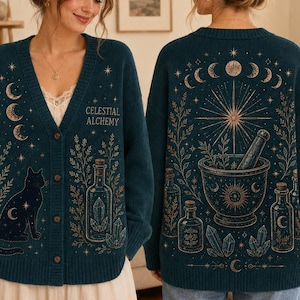 May include: A dark teal V-neck cardigan featuring a gold celestial print. The front displays a cat, crystals, and the text Celestial Alchemy. The back shows a large mortar and pestle, moon phases, and botanical elements in a gold line art style.