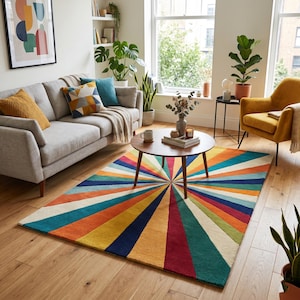 May include: A multi-coloured rug with a sunburst pattern in a living room. The rug displays a spectrum of colours, including orange, yellow, blue, and green. It's positioned on a wooden floor, enhancing the room's aesthetic.