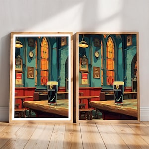 May include: Two framed prints depict a pub interior with a pint of Guinness on a wooden table. The artwork features a teal wall, red accents, and arched windows with orange light. The prints are in wooden frames and rest on a wooden floor.