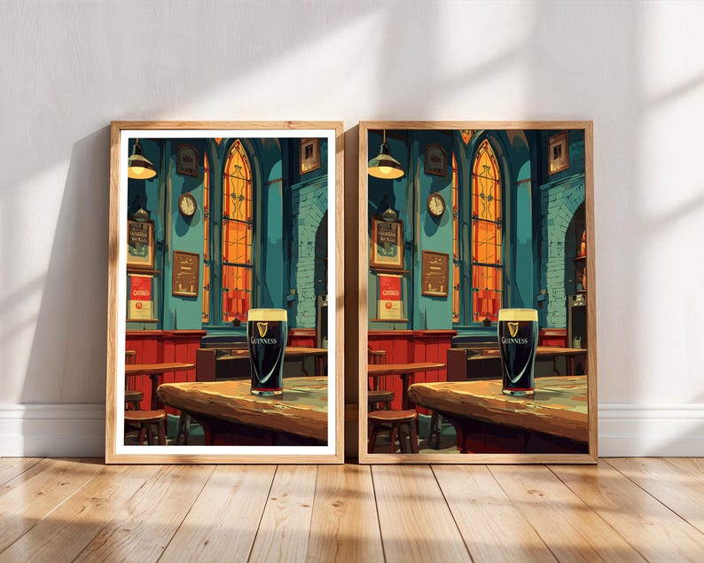 May include: Two framed prints depict a pub interior with a pint of Guinness on a wooden table. The artwork features a teal wall, red accents, and arched windows with orange light. The prints are in wooden frames and rest on a wooden floor.
