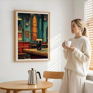 May include: A framed print depicts a pub scene with a pint of Guinness on a wooden table. The artwork features a stained-glass window, a clock, and various framed signs. The color palette includes shades of teal, red, and gold, creating a warm and inviting atmosphere.
