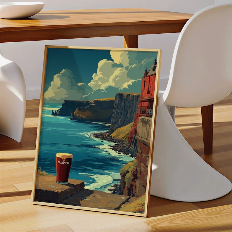 May include: Framed art print featuring a scenic coastal landscape with a pint of Guinness. The artwork depicts a cliffside view with a vibrant blue ocean, cloudy sky, and a red building. The Guinness glass is centered on a stone ledge.