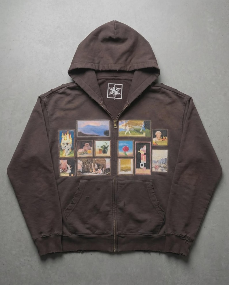 May include: A brown zip-up hoodie with a hood and a star logo on the chest. The front of the hoodie features a collage of framed images. The images include a skull, landscapes, and figures.