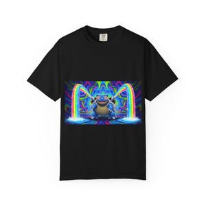 Puede incluir: Camiseta negra con un gráfico colorido de una criatura azul parecida a una tortuga con chorros de agua arcoíris. El diseño tiene un tema psicodélico con colores vibrantes y un estilo de dibujos animados.