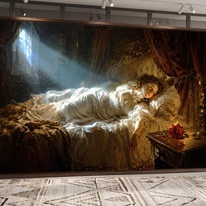 Puede incluir: Un gran cuadro rectangular de pared que muestra a una persona acostada en una cama en una habitaci&oacute;n con poca luz. Un rayo de luz ilumina a la persona, que viste una prenda blanca. Una rosa roja descansa sobre una mesita de noche de madera oscura.