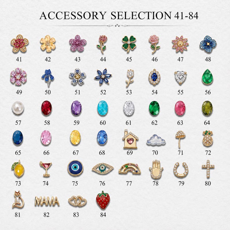 May include: A grid of small decorative charms labelled 41-84 under the text ACCESSORY SELECTION 41-84. The collection includes various shapes such as flowers, gemstones, fruits, symbols, and animals, featuring gold-tone metal and colourful accents.