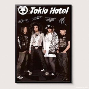 Puede incluir: Un póster enmarcado que muestra a la banda Tokio Hotel con cuatro miembros de pie en fila sobre un fondo negro. El nombre y el logotipo de la banda aparecen en la parte superior en texto blanco, junto a cuatro firmas manuscritas distintas.