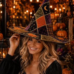May include: A pointed witch hat featuring a patchwork design with various textures and colors including purple, orange, green, and black. The hat is decorated with embroidered crescent moon motifs and orange pumpkin patterns along the wide brim.