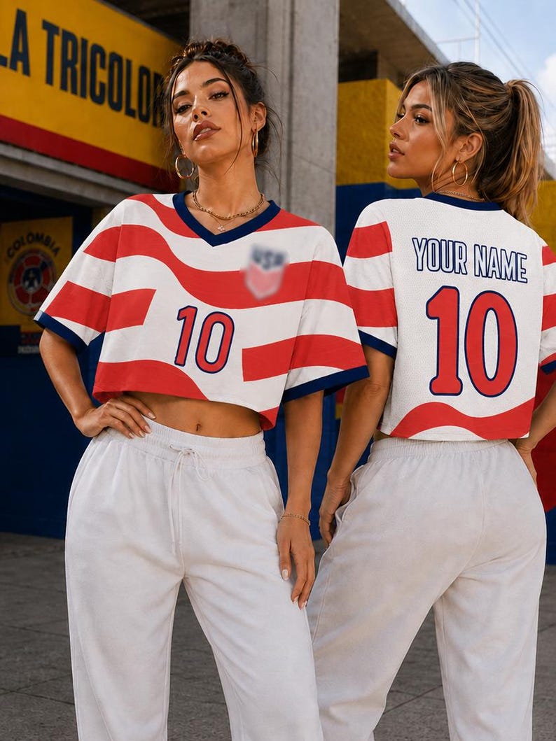 May include: A cropped V-neck jersey featuring a red and white wavy stripe pattern, a dark blue collar, and the number 10 in red on the front. The back displays the text YOUR NAME above the number 10 in red, with dark blue trim on the sleeves.
