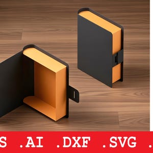 May include: Two black book-shaped boxes with orange interiors and a clasp closure are shown on a wooden surface. One box is open, revealing the interior. The image also includes a diagram of the box design and file type icons.