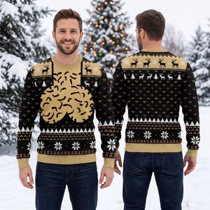 May include: A long-sleeve crew neck sweater featuring a black and tan color scheme with a repeating pattern of reindeer, pine trees, and snowflakes. The front displays a large, abstract tan graphic on a black background, while the back features a horizontal band of reindeer and trees above a geometric snowflake design.