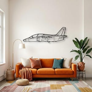 May include: A black metal wall art piece shaped like the side profile of a jet aircraft. The design features a minimalist outline of the fuselage, wings, cockpit canopy, and tail fin, constructed from thin, interconnected metal lines.