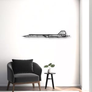 Op de afbeelding: Een zwart metalen wanddecoratie in de vorm van het silhouet van een SR-71 Blackbird vliegtuig. Het ontwerp toont de lange, slanke romp, de spitse neus, de deltavleugels en de verticale stabilisatoren van dit iconische verkenningsvliegtuig.