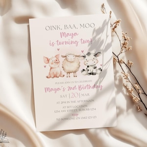 Puede incluir: Una invitación de cumpleaños rosa claro con el texto "OINK, BAA, MOO ¡Maya cumple dos años!" e ilustraciones de un cerdo, una oveja y una vaca. La invitación incluye detalles para el 2º cumpleaños de Maya.