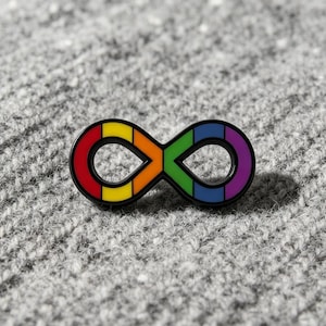 May include: A metal pin shaped like an infinity symbol, featuring a black outline and segmented sections colored in red, yellow, orange, green, blue, and purple. The design is symmetrical, with the colors arranged in a vibrant rainbow gradient.