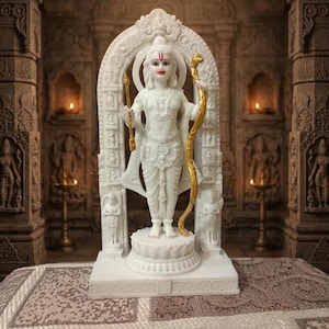 May include: A white marble statue of a deity, standing on a lotus base, holding a bow and arrow. The statue is framed by an ornate archway and set against a backdrop of a temple interior. The bow and arrow have gold accents.