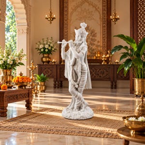 May include: A white marble-effect statue of a standing figure playing a flute. The figure wears a crown, a draped garment, and a garland around the neck. The statue is positioned on a textured, circular base, showcasing intricate details in the carving.