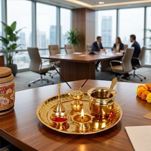 May include: A polished brass puja thali set featuring a round tray, a small bell, a diya lamp with a lit flame, a small bowl containing red powder, a cylindrical incense holder with two sticks, and a small pot with a spoon inside.