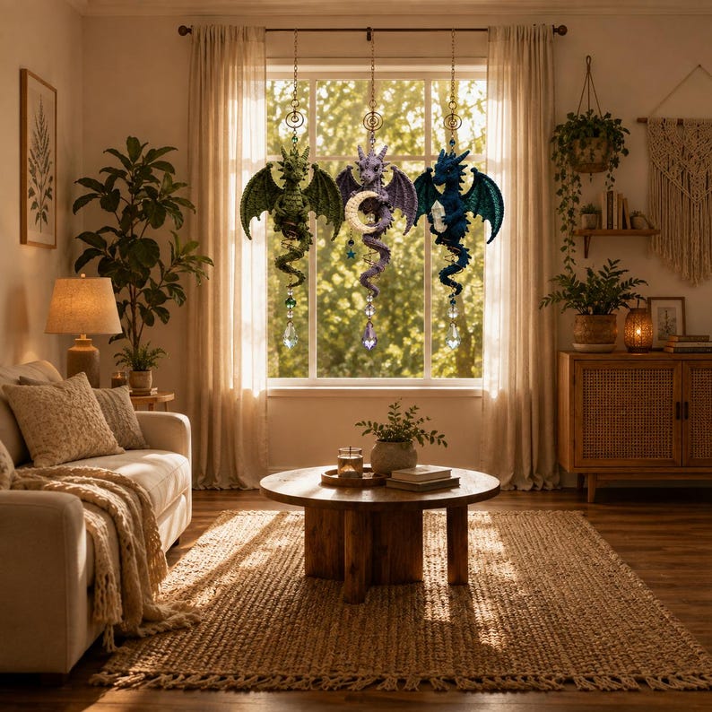 May include: Three hanging dragon ornaments suspended in a window. The left dragon is green, the center is purple holding a crescent moon, and the right is blue holding a crystal. Each dragon features a dangling faceted crystal prism at the base.