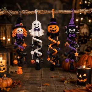 May include: Four crocheted Halloween hanging ornaments featuring a witch with orange hair, a white ghost, an orange jack-o'-lantern, and a black cat. Each figure wears a hat and a bow tie, suspended above a spiral tail decorated with small charms.