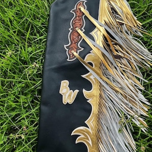 Anpassade läderrodeochaps Handgjorda blommönster Metalliska guldfransar Westernridutrustning Pro Rodeochaps Anpassade läderrodeochaps Western