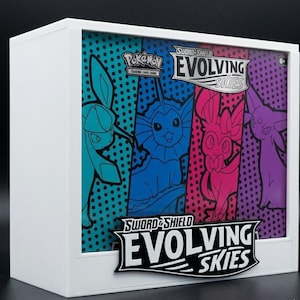 May include: A white display box for the "Pokémon Trading Card Game: Sword & Shield - Evolving Skies" set. The box art features four Pokémon characters in blue, pink, and purple, with the set's logo clearly visible.