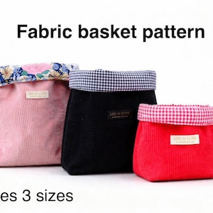 May include: Three fabric baskets in pink, black, and red corduroy, each with a patterned lining. The pink basket has a floral lining, the black has a gingham lining, and the red has a gingham lining. The text "Fabric basket pattern" and "Includes 3 sizes" are visible.
