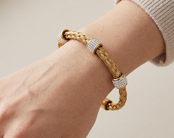 Bracciale rigido intrecciato in oro, delicato gioiello traforato con zirconi, un regalo perfetto per lei.