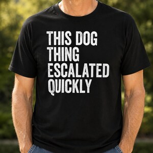 Puede incluir: Una camiseta negra de manga corta con texto blanco de estilo desgastado en la parte delantera que dice, THIS DOG THING ESCALATED QUICKLY. La prenda tiene cuello redondo y un corte estándar, con el gráfico centrado en la zona del pecho.