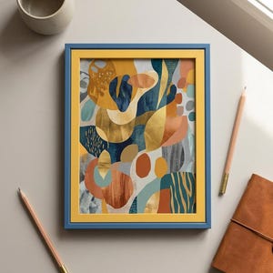 Puede incluir: Una lámina de arte enmarcada que presenta una composición abstracta de formas orgánicas en tonos amarillo mostaza, azul marino, terracota y oro metálico. La obra está dentro de un marco de doble capa con un borde interior amarillo y uno exterior azul.