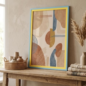 May include: A rectangular wall art print in a bright yellow and light blue frame. The artwork features abstract shapes in shades of terracotta, muted blue, and beige, including circles, semi-circles, and line patterns on a light background.