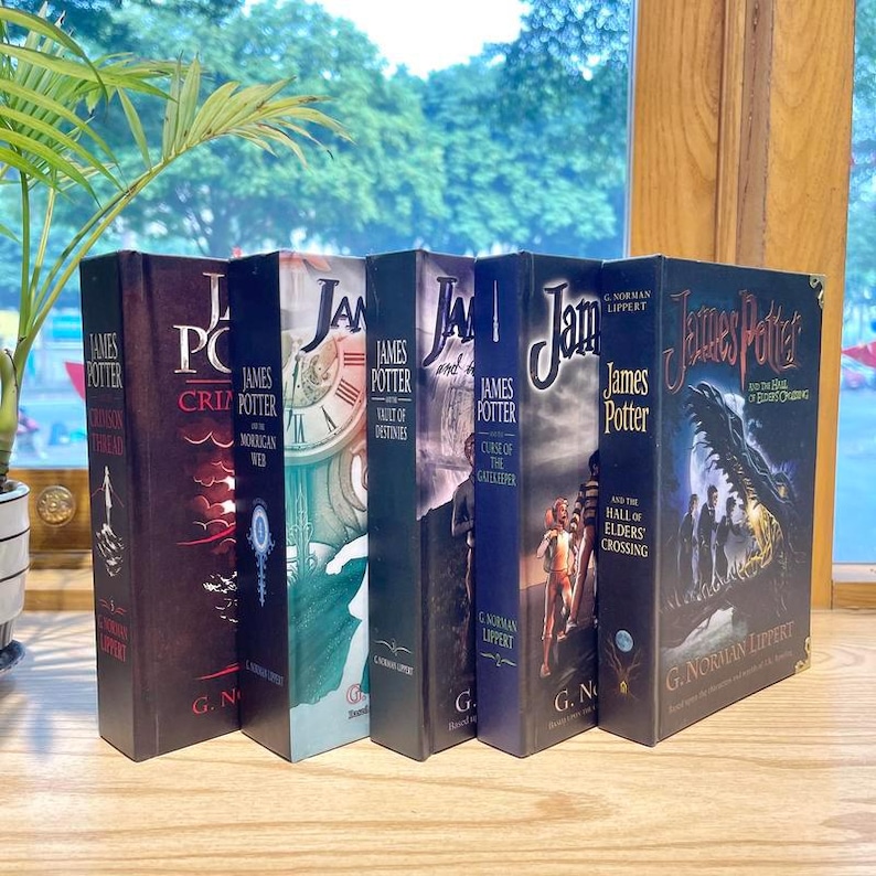 May include: A collection of five hardcover books from the James Potter series by G. Norman Lippert, including titles such as Crimson Thread, The Morrigan Web, Vault of Destinies, Curse of the Gatekeeper, and The Hall of Elders' Crossing, standing upright.