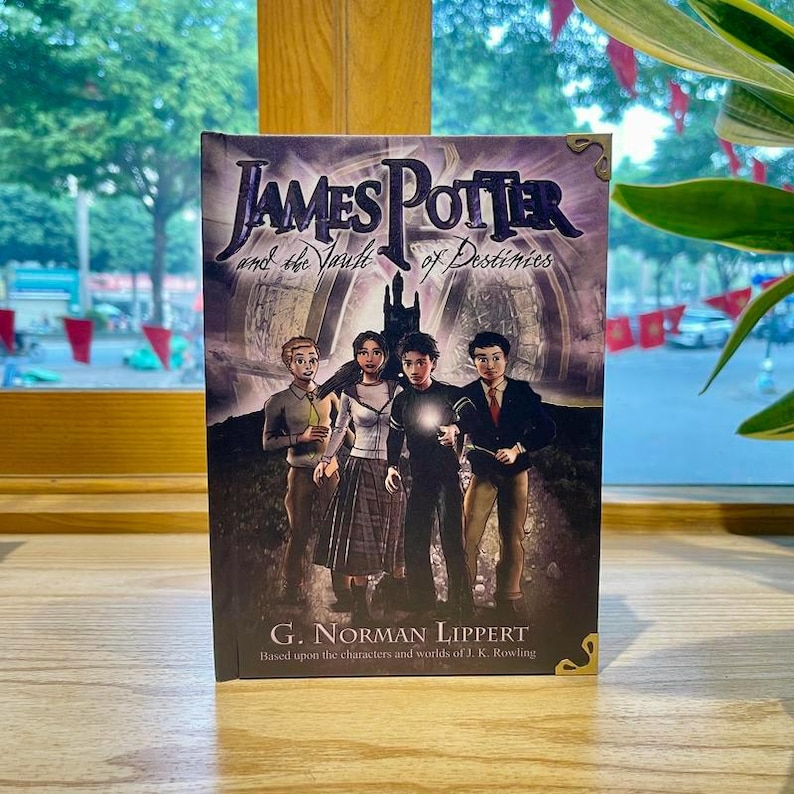 May include: A hardcover book titled James Potter and the Vault of Destinies by G. Norman Lippert. The cover features a purple and black illustration of four young characters standing before a dark castle, with one character holding a glowing light.