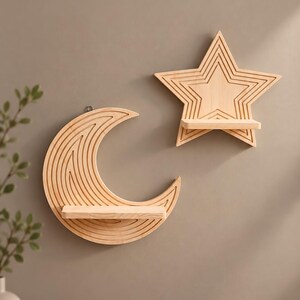 Può includere: Due mensole da parete in legno chiaro. Una mensola ha la forma di una luna crescente con linee incise concentriche, l'altra ha la forma di una stella a cinque punte con linee incise concentriche. Ogni pezzo presenta un ripiano orizzontale.