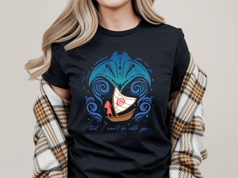 Op de afbeelding: Zwart t-shirt met een kleurrijk ontwerp van een boot en een personage, omringd door wervelende blauwe golven en decoratieve elementen. De tekst luidt: "There is nowhere that I won't be with you..."