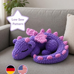May include: A purple and pink crocheted dragon plush toy with a curled tail, wings, and spikes along its back. A white star-shaped graphic in the upper left corner contains the text Low Sew Pattern. Two circular icons with German and American flags.