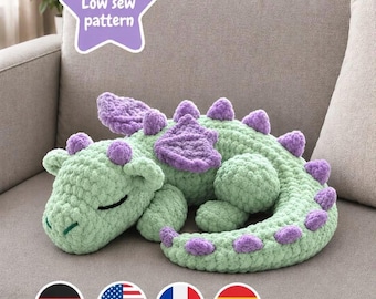May include: A light green crocheted dragon plush toy with purple wings and purple spikes along its back and tail. The dragon has closed eyes and a curled tail. A purple star-shaped graphic in the upper left corner contains the text Low sew pattern.