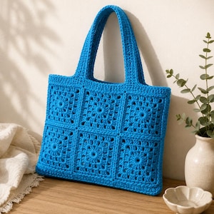 May include: A bright blue tote bag constructed from six square crochet granny motifs arranged in two rows of three. The bag features two matching blue crochet handles and a textured, open-work pattern throughout the entire surface of the bag.