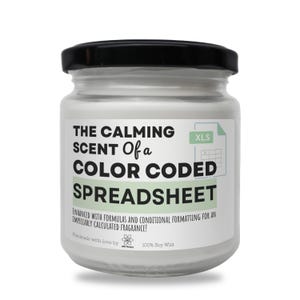 Könnte beinhalten: Eine weiße Kerze in einem Glas mit schwarzem Deckel. Auf dem Etikett steht "THE CALMING SCENT Of a COLOR CODED SPREADSHEET". Die Kerze ist mit Formeln und bedingter Formatierung für einen tadellosen Duft versehen. Sie ist handgefertigt mit 100% Sojawachs.
