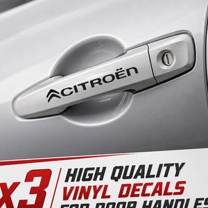 Może przedstawiać: Srebrna klamka samochodowa z czarną naklejką z logo Citroën. Poniżej klamki znajduje się tekst: x3 HIGH QUALITY VINYL DECALS FOR DOOR HANDLES. Naklejka jest umieszczona bezpośrednio na powierzchni klamki, która posiada otwór na klucz.