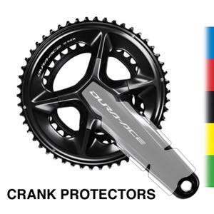 Può includere: Una guarnitura per bicicletta Dura-Ace nera con una protezione. La guarnitura ha una corona circolare con più denti e un design a ragno a cinque bracci. Il testo "DURA-ACE" è visibile sulla guarnitura e sulla protezione. Le parole "CRANK PROTECTORS" sono in basso.
