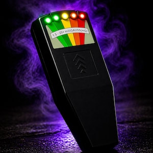 May include: Black EMF meter with a colour-coded display showing readings from 1.5 to 25+ milliGAUSS(mG). The device has a series of coloured lights, ranging from green to red, and an arrow symbol. The background features a purple smoky effect.