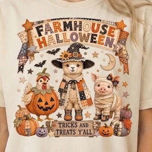 May include: A cream-colored t-shirt featuring a graphic of a llama in a witch hat, a chicken inside a pumpkin, and a pig wrapped like a mummy. The text reads FARMHOUSE HALLOWEEN and TRICKS AND TREATS Y'ALL, surrounded by stars, bats, and moons.