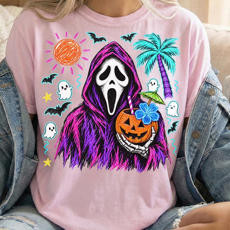 May include: A light pink t-shirt featuring a graphic of a hooded figure with a white mask holding a carved pumpkin with a straw and a blue flower. The design includes a bright orange sun, a teal palm tree, small white ghosts, bats, and yellow stars.