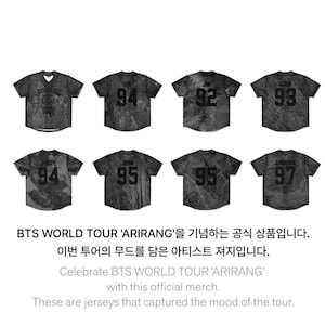 Könnte beinhalten: Acht dunkelgraue Baseball-Trikots sind abgebildet. Jedes Trikot hat eine andere Nummer auf dem Rücken. Der Text unten lautet: "Celebrate BTS WORLD TOUR 'ARIRANG' with this official merch."