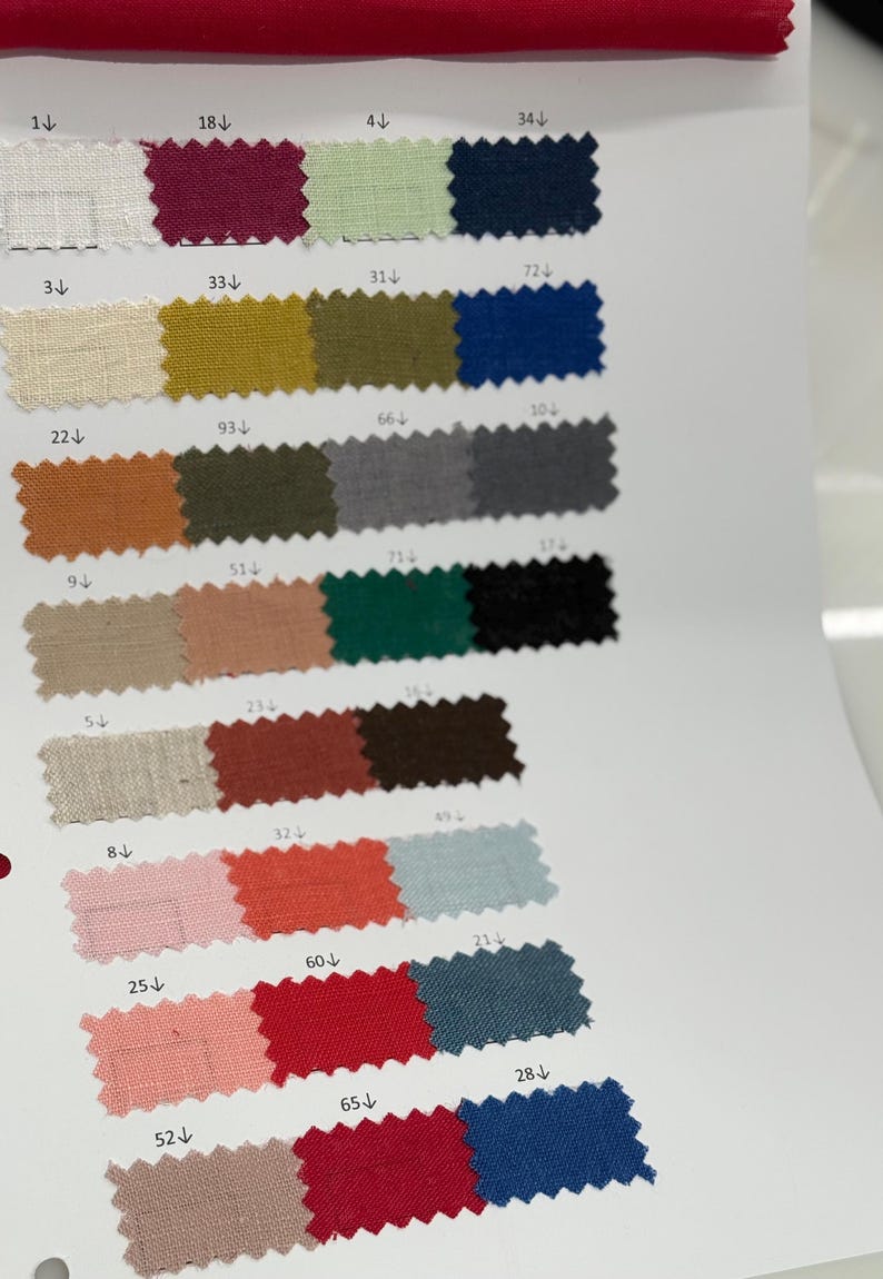 May include: A fabric swatch card featuring a variety of colors, including white, burgundy, green, navy, beige, gold, orange, pink, red, and blue. Each color is labeled with a number.