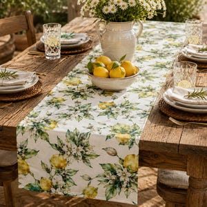 May include: A rustic wooden dining table set for a meal. The table is adorned with a lemon-themed runner, white plates, woven placemats, and glasses. A bowl of lemons and a vase of daisies complete the setting, creating a fresh, inviting atmosphere.