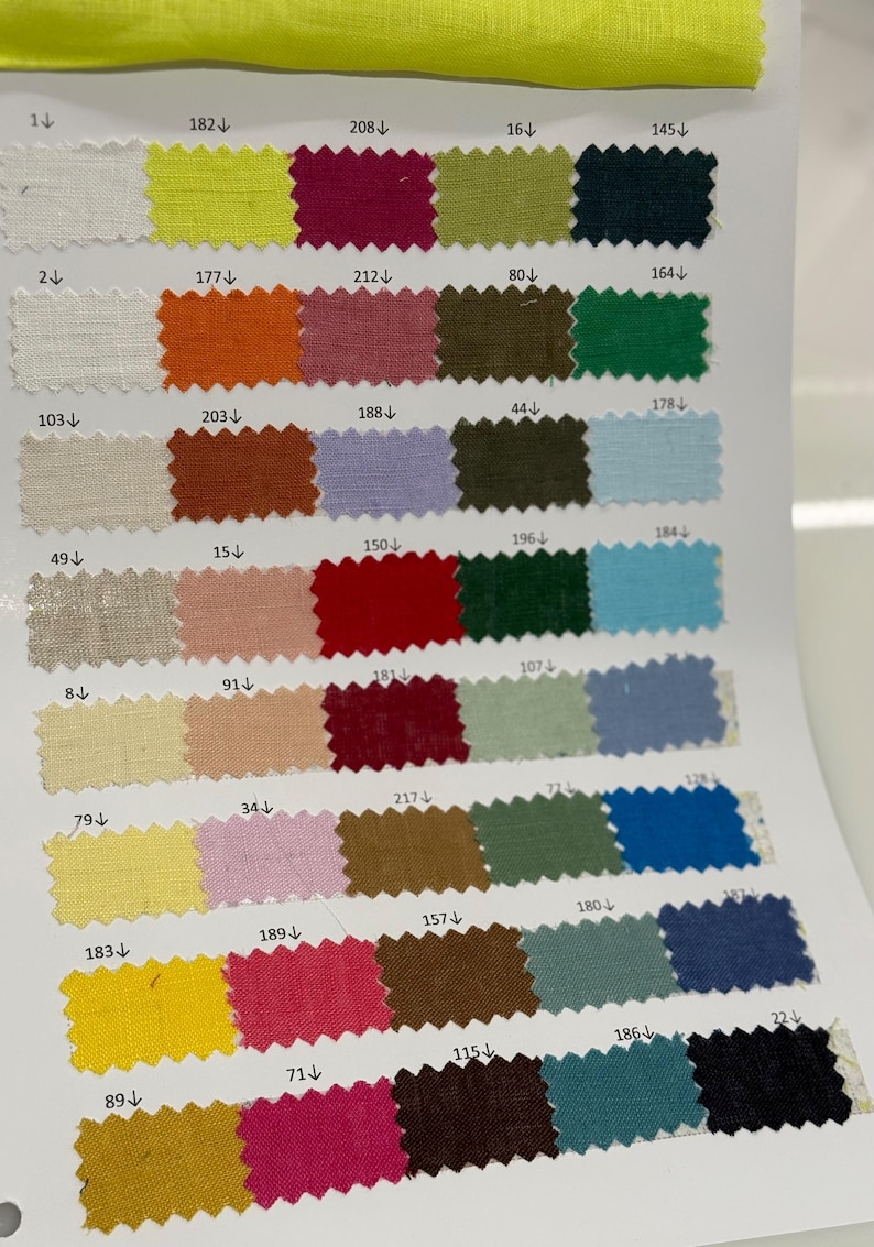 May include: A fabric color swatch card featuring a variety of fabric samples in various colors. The samples are arranged in rows and columns, showcasing shades of white, yellow, orange, pink, red, green, blue, and brown.